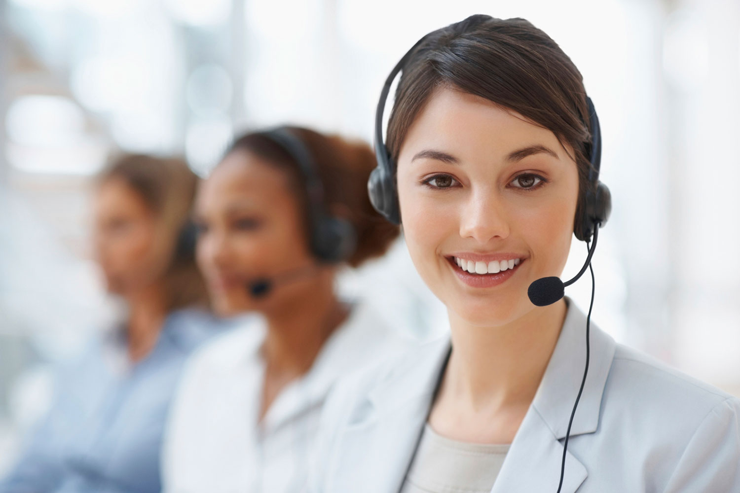 Professional woman wearing a headset, seated at a desk, ready to assist customers
