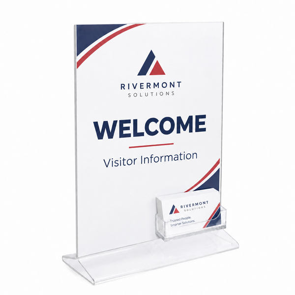 Clear acrylic welcome sign stand with a white insert displaying 'RIVERMONT SOLUTIONS WELCOME Visitor Information' and a small clear business card holder at the base, shown on a white background.