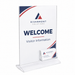 Clear acrylic welcome sign stand with a white insert displaying 'RIVERMONT SOLUTIONS WELCOME Visitor Information' and a small clear business card holder at the base, shown on a white background.